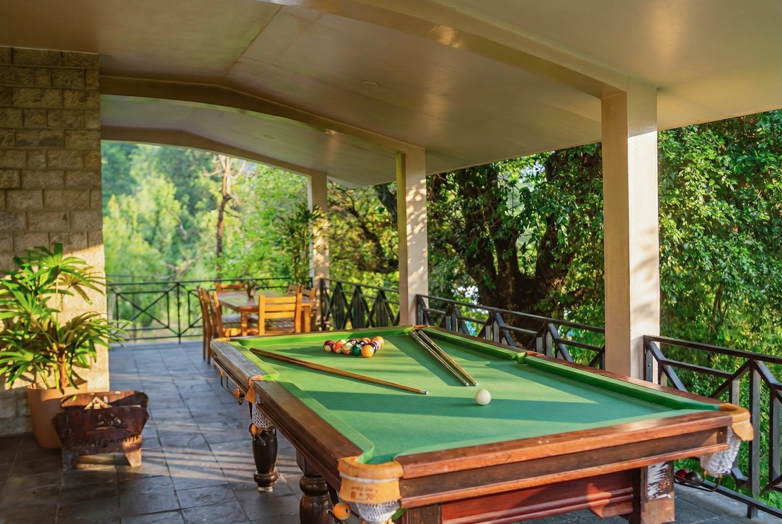 Garden area with seating and multi-level balconies offering stunning mountain backdrop at Forestbound Cottage in Manali